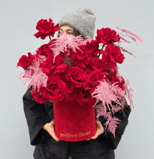 A bouquet of red roses with asparagus in a box